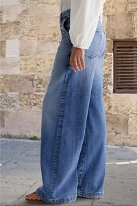 Vue latérale du jean denim bleu à taille haute et jambe large pour femme en coupe relax