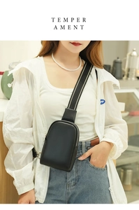 Close-up of a black matte leather chest bag with adjustable wide strap on a model