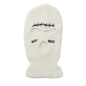 Detail of cream knit balaclava with three-hole design and black NOT NICE embroidery