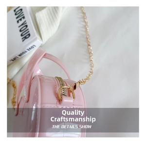 Detailed close-up of pink heart-shaped jelly bag with gold metal zipper and chain strap