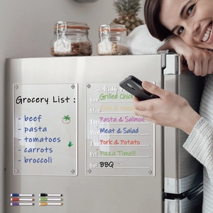 Detailed view of clear acrylic magnetic weekly planners and markers on a refrigerator