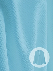 Macro view of light blue polo fabric texture showing fine checkered knit detail