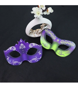 Detail view of purple and green masquerade masks with silver glitter scroll patterns
