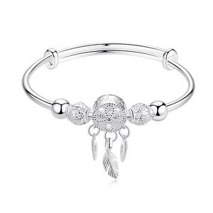 Detail of silver dreamcatcher bracelet featuring hollow ball and three feather charms