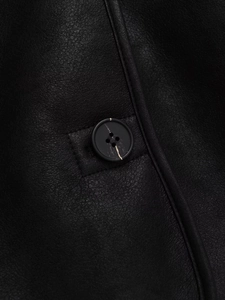 Close-up of black faux suede jacket featuring precise stitching and classic four-hole buttons