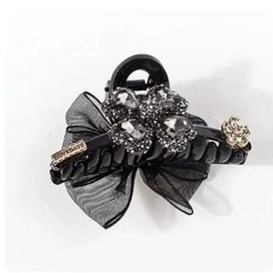 Elegant black hair claw clip with mesh bow and crystal clover on white background