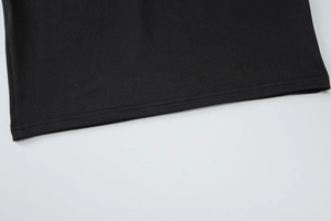 Close-up of the black fabric texture and high-quality bottom hem stitching details