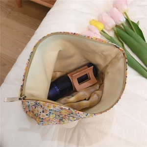 Detailed interior of a floral cotton makeup bag showing spacious storage with zipper