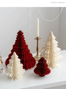 Detail of red and white honeycomb paper Christmas trees with festive decor props