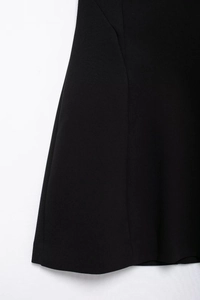 Gros plan des coutures latérales et de l'ourlet d'une robe noire en velours doux