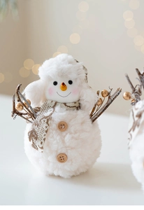 Close-up of plush Christmas snowman doll with soft fleece texture and warm festive lights