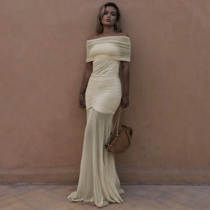Detail of light yellow off-shoulder pleated mesh maxi dress with sheer patchwork texture