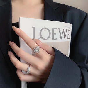 Close-up of heart-shaped faux moissanite ring and eternity band on model's hand