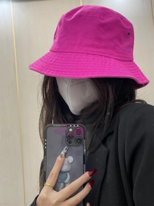 Detailed close-up of a vibrant rose red cotton bucket hat worn by a female model