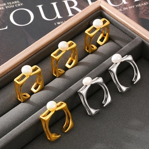 Square open rings in gold and silver finish with pearl inlay on a velvet display tray