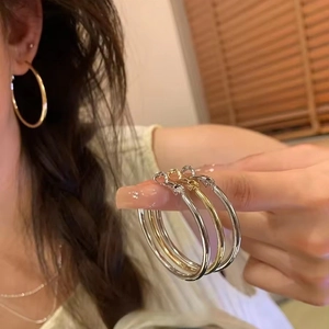 Minimalist gold and silver geometric hoop earrings for women shown in lifestyle setting