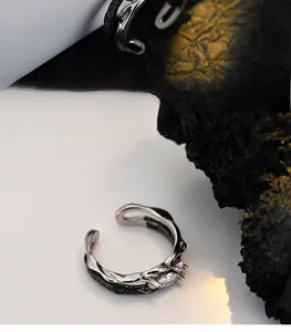 Macro detail of bicolored S925 silver ring with marquise zircon and raw tree branch texture