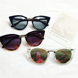 Retro cat-eye sunglasses for women in black, tortoiseshell and clear frames on white fabric