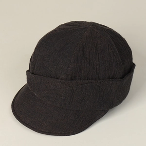 Detailed macro view of dark wrinkled texture fabric and stitched brim on newsboy cap
