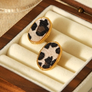 Oval 18K gold stainless steel earrings with leopard print fur texture in a wooden jewelry box