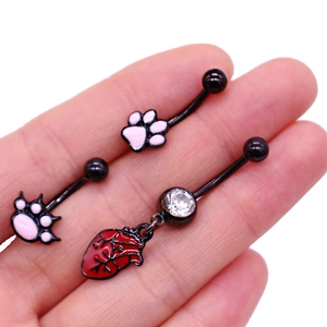 Vue détaillée de piercings de nombril noirs avec patte rose et pendentif coeur