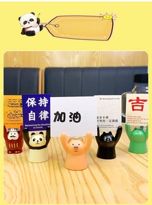 Close-up of cute cartoon resin animal card holders on a wooden desk with various styles