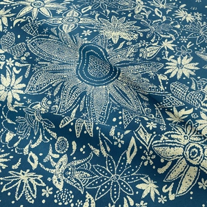 Dettaglio del tessuto dell'arazzo bohémien blu scuro con motivi floreali bianchi e trama