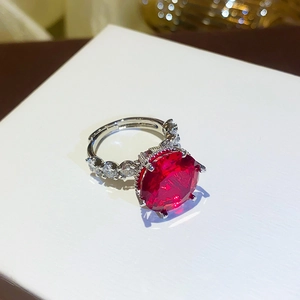 Macro detail of silver ring featuring a large round red zircon with prong setting
