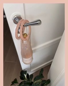 Detail of pink pearlescent mesh wine bag with transparent acrylic ring handles