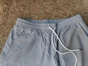 Detailansicht des elastischen Bundes mit weißem Kordelzug an hellblauen Cargo-Shorts