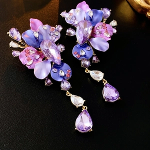 Macro detail of purple floral earrings with crystal droplets and layered petals