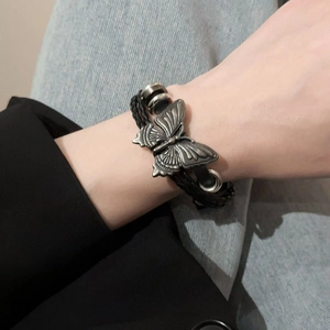 Détail du bracelet en cuir tressé à la main avec breloque papillon en argent antique