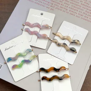Set of 4 pairs of wavy acetate hair clips with stylish resin patterns and gold base