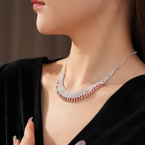 Detail of silver tassel necklace with pink and white crystals on a model's neck
