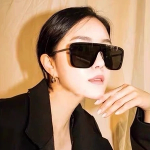 Close-up of oversized black square sunglasses showing face proportions and stylish fit