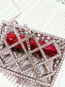 Detail of silver rhinestone hollow mini bag with a red lipstick and chain strap