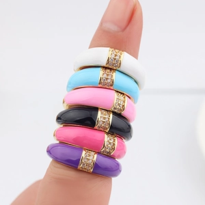 Close-up of colorful enamel stackable rings with sparkling crystal inlay on model fingers