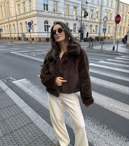 Deep brown faux fur jacket styled with cream wide-leg pants in an urban street setting