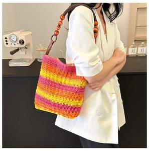 Detail of multi-color striped woven straw bag with unique round wooden bead handle