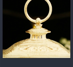 Close-up of vintage Christmas lantern top with cream finish and elegant embossed details