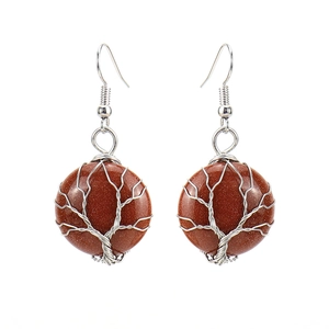 Detailed shot of handmade tree of life earrings with brown goldstone and silver wire wrap