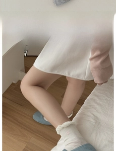 Detail of white mesh socks with ruffled cuffs and pink heart embroidery on the side