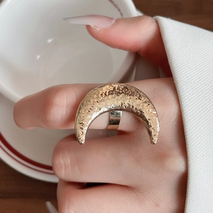 Detailansicht eines breiten goldenen Mondsichel-Rings mit gehämmerter Metalloberfläche