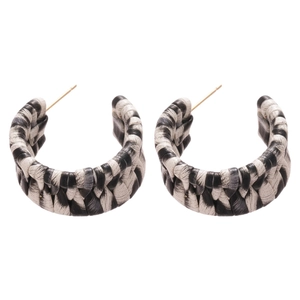 Retro C-shaped earrings with black and white woven leather texture on a white background