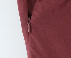 Close-up of a burgundy tiered mini dress showing a neat invisible zipper and fabric