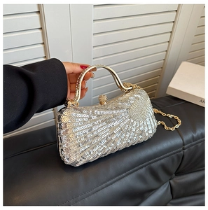 Detail of silver sequin evening clutch bag with golden metal frame and chain strap