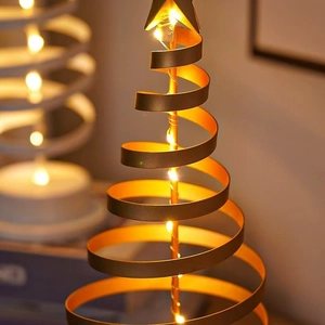 Close-up of golden metal spiral Christmas tree lamp with warm LED lights and star topper