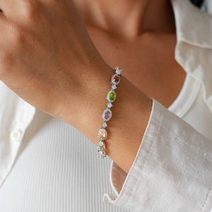 Detailed shot of a luxury multicolored gemstone bracelet on a wrist with silver clasp