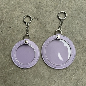 Close-up of lavender faux leather round charm bags with transparent windows in two sizes