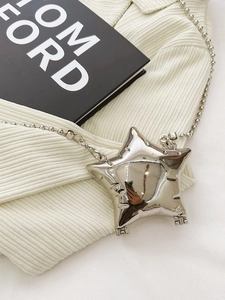 Polished silver star-shaped mini crossbody bag with metallic chain on white fabric